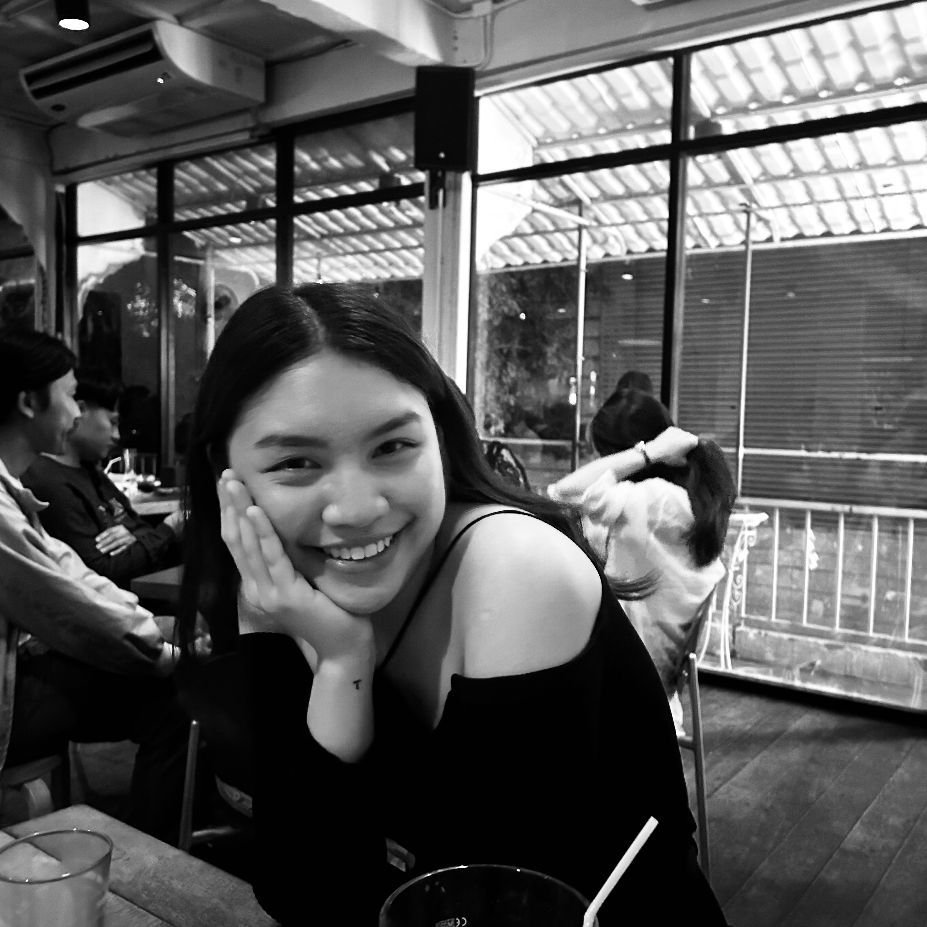 Thawanrat smiling in a café
